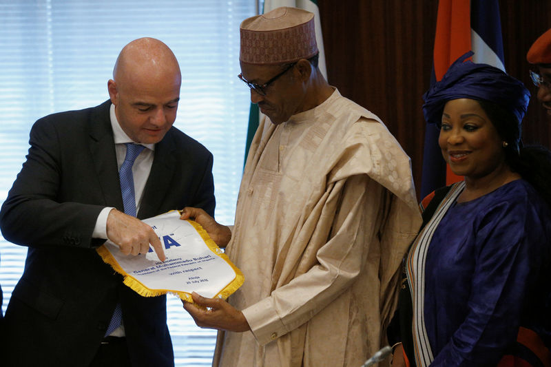 © Reuters. Buhari receives a present from Infantino in Abuja