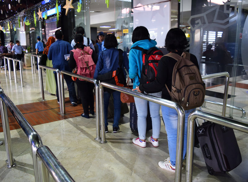 © Reuters. A group of domestic helpers leaving for Hong Kong pass through the security check at Jakarta's Soekarno-Hatta airport