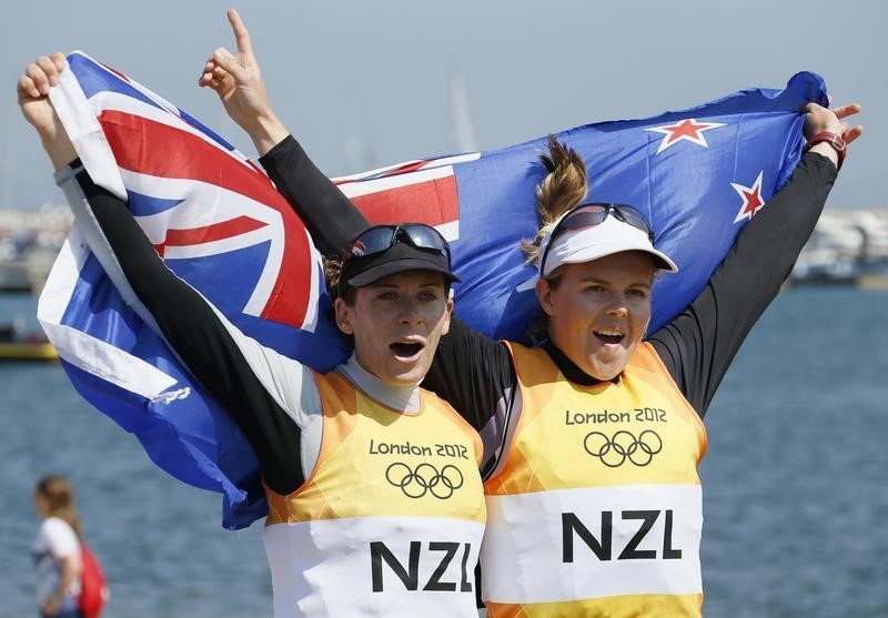 © Reuters. New Zealand's Jo Aleh and Olivia Powrie celebrate as they arrive in the harbour after winning gold in the women's 470 sailing class at the London 2012 Olympic Games