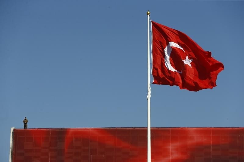 © Reuters. Un uomo della sicurezza di servizio su un tetto ad Istanbul durante una manifestazione del principale partito dell'opposizione