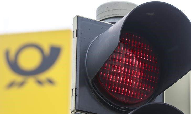 © Reuters. The logo of German mail carrier Deutsche Post is seen next to a red traffic light during a demonstration Munich