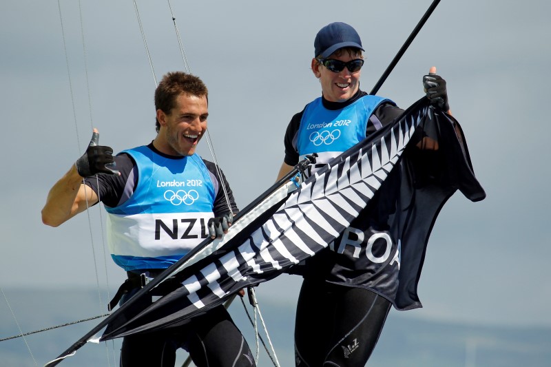 © Reuters. New Zealand's Peter Burling and Blair Tuke celebrate as they cross the finish line to win silver in the 49er sailing class at the London 2012 Olympic Games