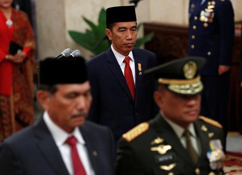 © Reuters. Indonesia's President Joko Widodo walks past the armed forces chief General Gatot Nurmantyo and  Coordinating Political, Legal and Security Affairs Minister Luhut Pandjaita during the inauguration of the new national police chief in Jakarta