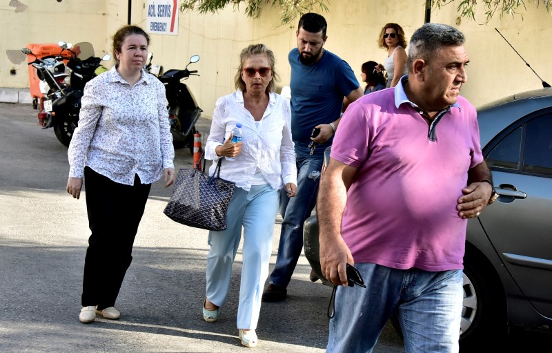 © Reuters. Turkish journalist Nazli Ilicak is escorted by a police officer and her relatives after being detained and brought to a hospital for a medical check in Bodrum