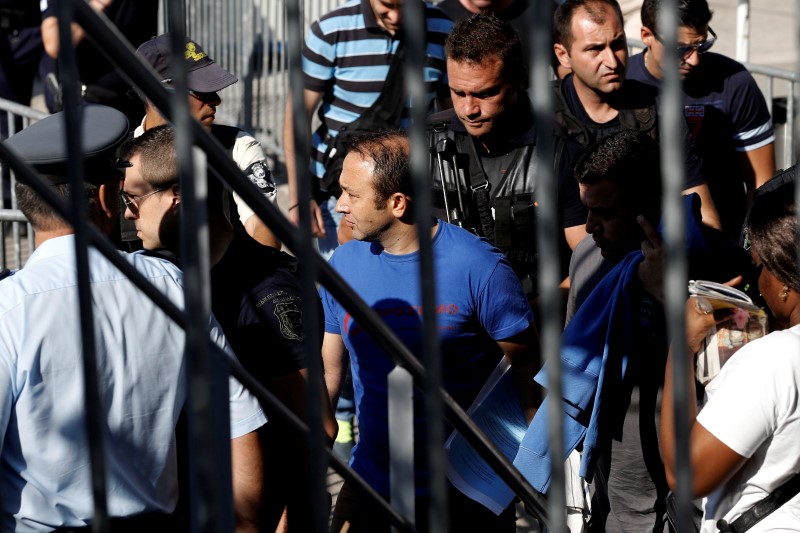 © Reuters. A Turkish soldier, who fled to Greece in a helicopter and requested political asylum after a failed military coup against the government, is escorted by special police forces in Athens