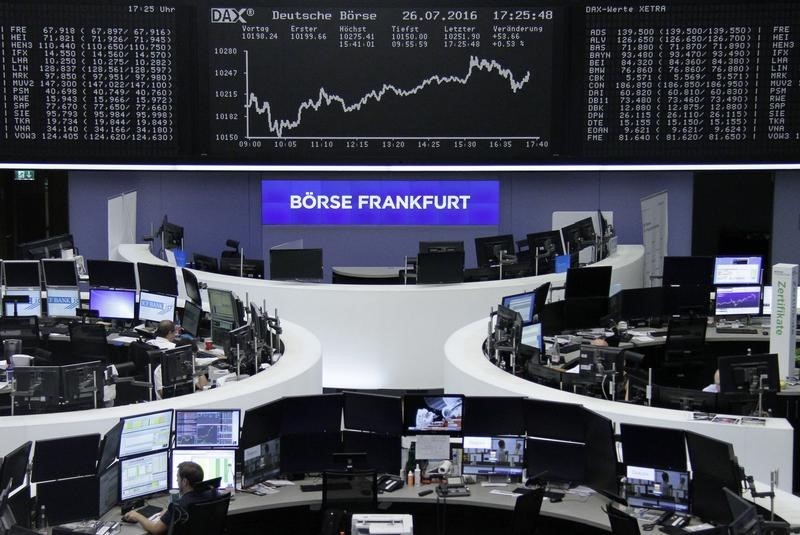 © Reuters. Traders work at their desks in front of the German share price index DAX board in Frankfurt