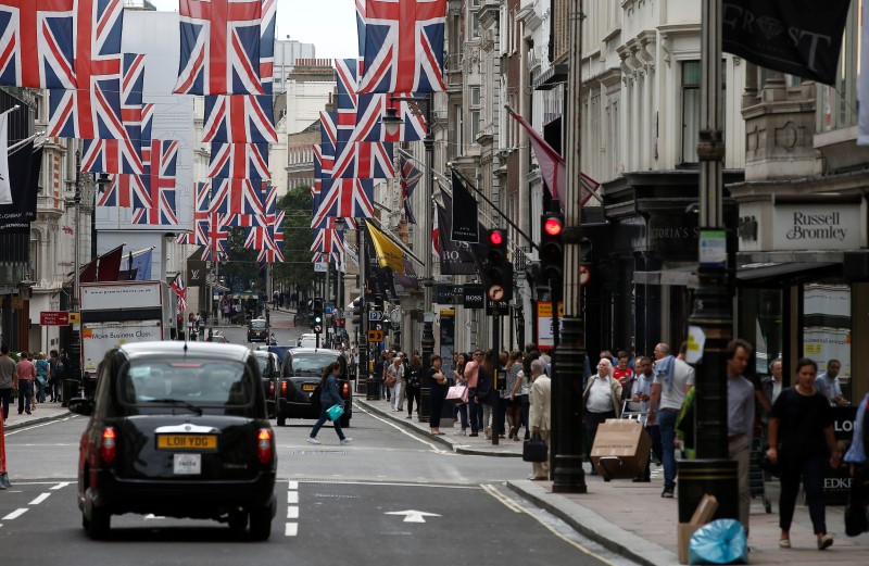 © Reuters. Shoppers walk past stores on New Bond Street in London