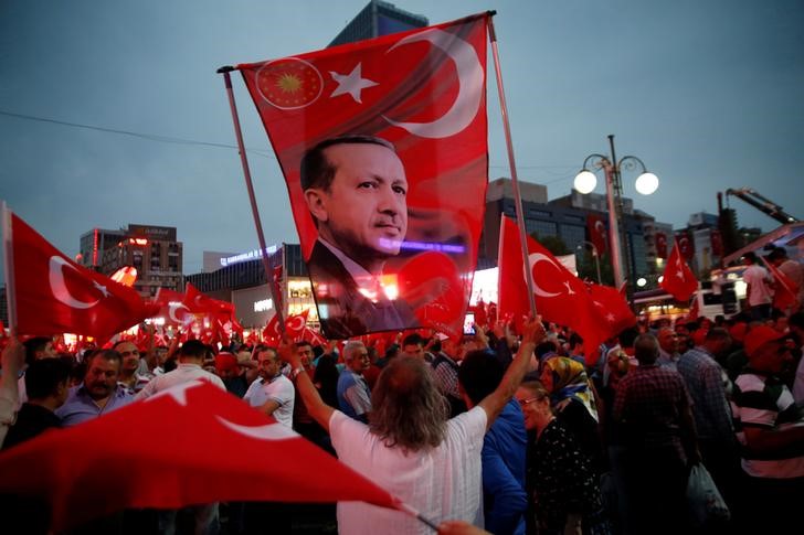 © Reuters. A supporter holds a flag depicting Turkish President Tayyip Erdogan during a pro-government demonstration in Ankara, Turkey