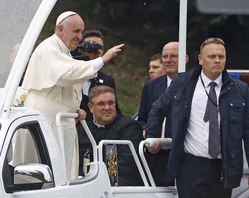 © Reuters. Pope Francis waves at the faithfuls as he travels to a welcoming ceremony at Wawel Royal Castle in Krakow