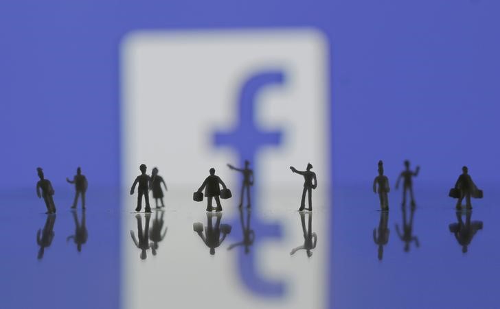 © Reuters. Photo illustration of 3D-printed models of people in front of a Facebook logo