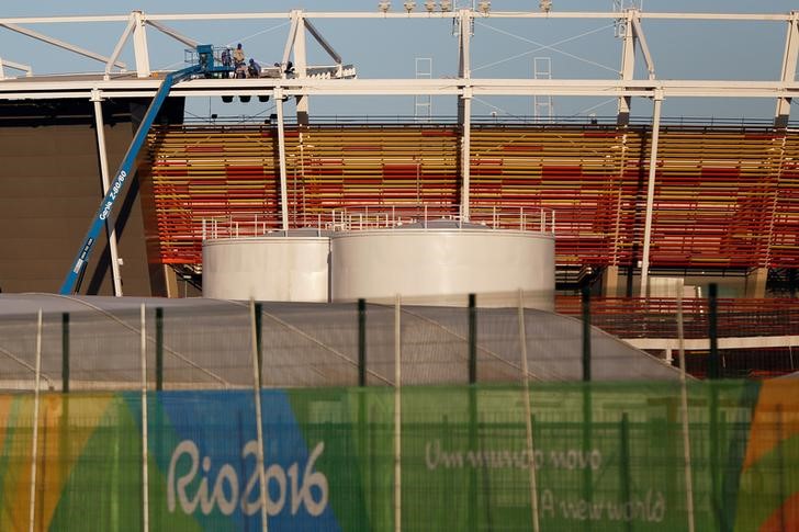 © Reuters. Workers are pictured in the tennis venue at the 2016 Rio Olympics Park in Rio de Janeiro