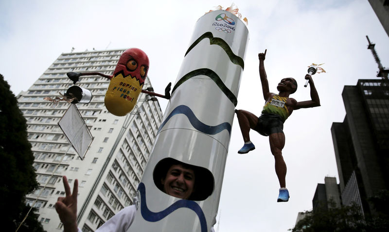 © Reuters. A runner is dressed in a costume depicting the Rio 2016 Olympic torch before the annual "Sao Silvestre Run" in Sao Paulo