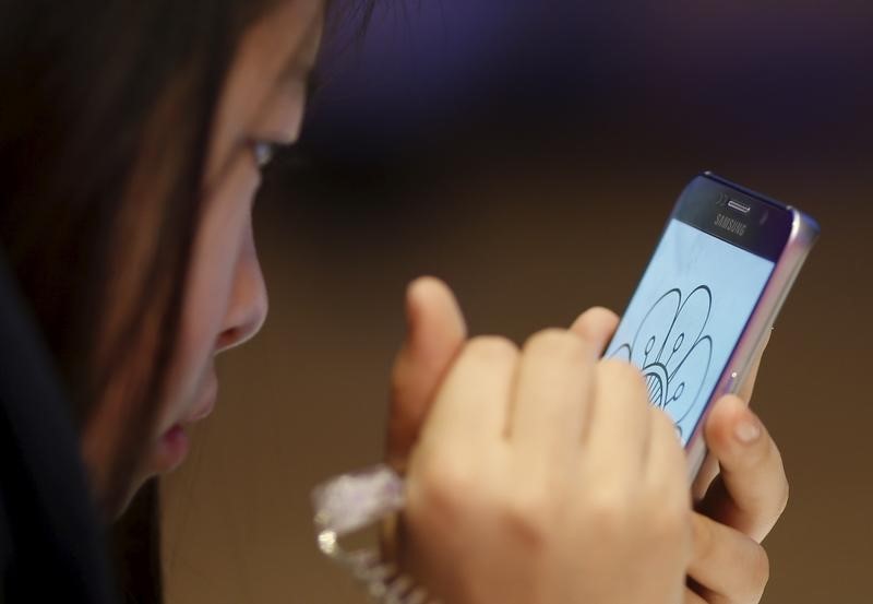 © Reuters. A girl tries out a Samsung Electronics' smartphone Galaxy Note 5 at its headquarters in Seoul