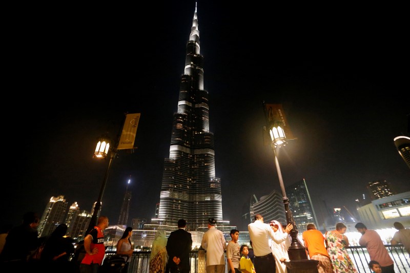 © Reuters. People look at Burj Khalifa, currently the tallest building in the world, in Dubai