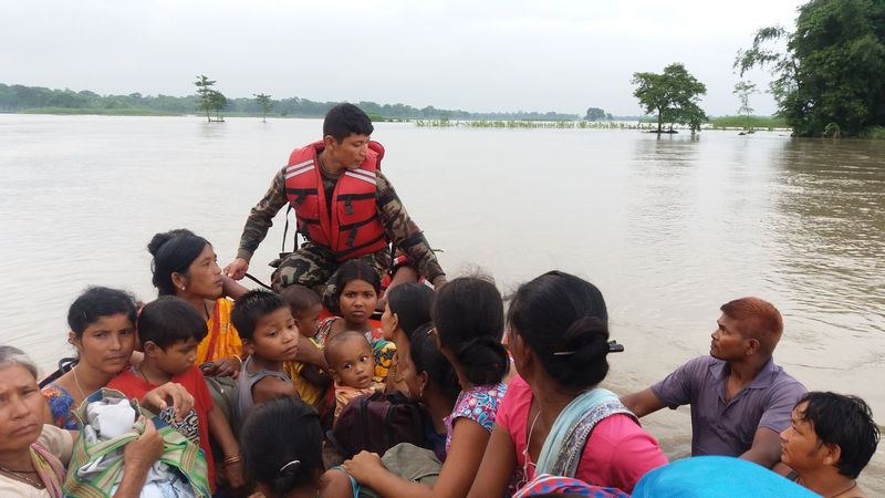© Reuters. An army officer assists flood victims in Jhapa