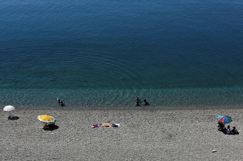 © Reuters. Tourists enjoy a beach in the Mediterranean resort city of Antalya
