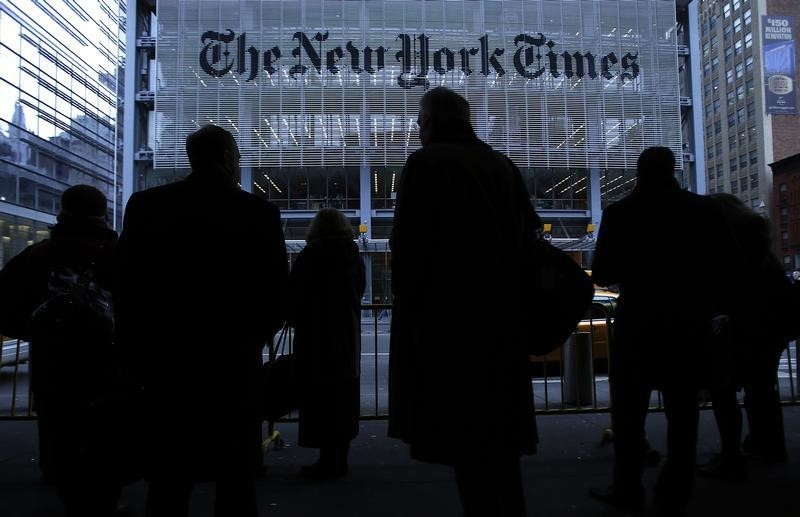 © Reuters. People line up for taxi across the street from the New York Times head office in New York