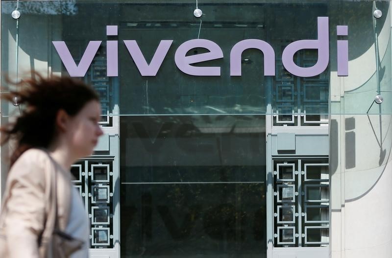 © Reuters. A woman walks walk past the main entrance of the entertainment-to-telecoms conglomerate Vivendi's headquarters in Paris