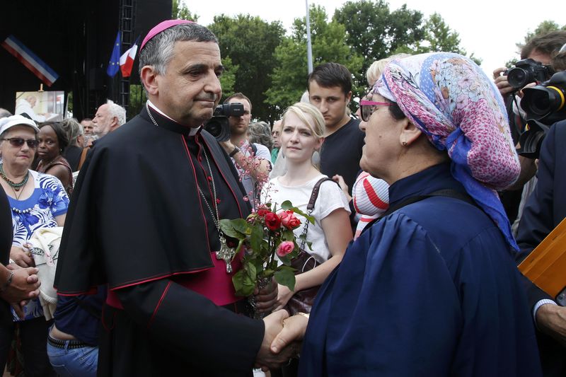 © Reuters. Archbishop of Rouen and Primate of Normandy Mgr Dominique Lebrun greets people in Saint-Etienne-du-Rouvray, near Rouen, France, who gather to pay tribute to French priest, Father Jacques Hamel