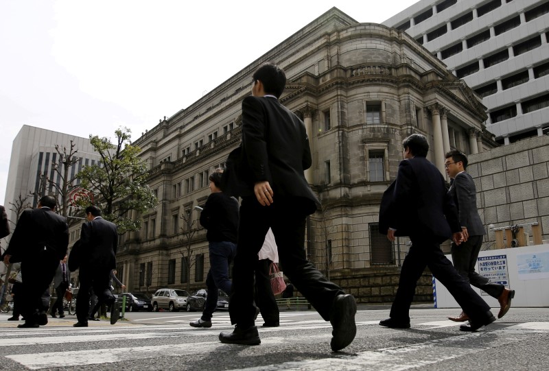 © Reuters. Businessmen walk past the Bank of Japan (BOJ) building in Tokyo