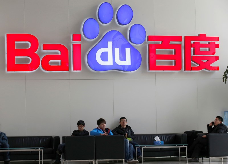 © Reuters. People sit in front of the company logo of Baidu at its headquarters in Beijing