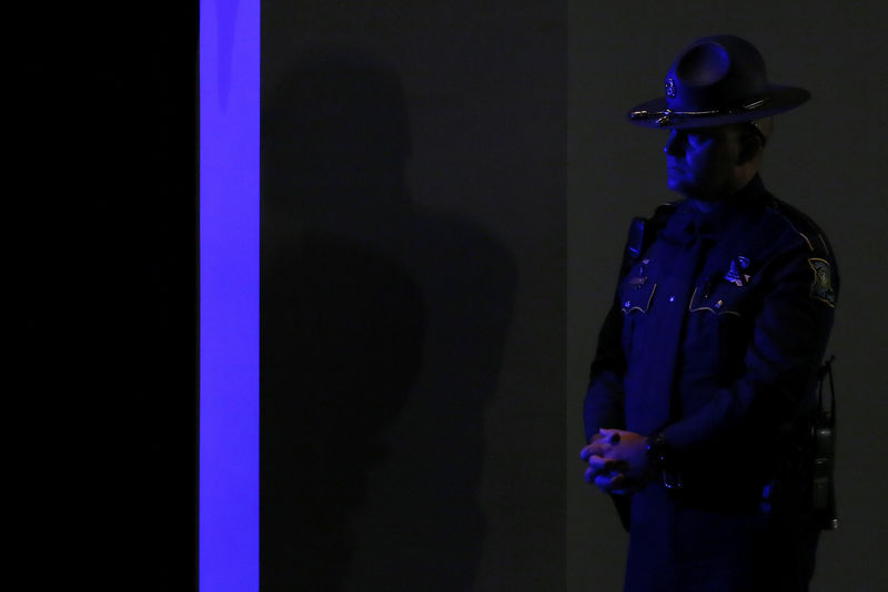 © Reuters. A Louisiana State Trooper stands at attention during a memorial service for three slain Baton Rouge police officers at Healing Place Church in Baton Rouge