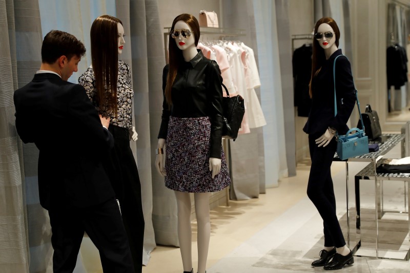 © Reuters. A shop assistant adjusts a mannequin at Dior's new flagship store in London