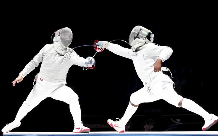 © Reuters. Russia's Alexey Yakimenko (L) competes against Daryl Homer of the U.S. during their men's sabre final at the World Fencing Championships in Moscow