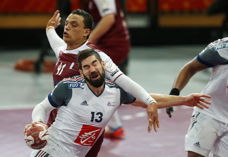 © Reuters. Karabatic of France blocked by Benali of Qatar during their final match of the 24th Men's Handball World Championship in Doha