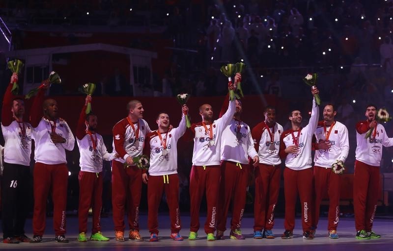 © Reuters. Players of Qatar's team celebrate during the award ceremony after winning second place of the 24th Men's Handball World Championship in Doha