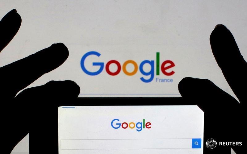 © Reuters. File photo of a woman holding her smart phone which displays the Google home page, in this picture illustration