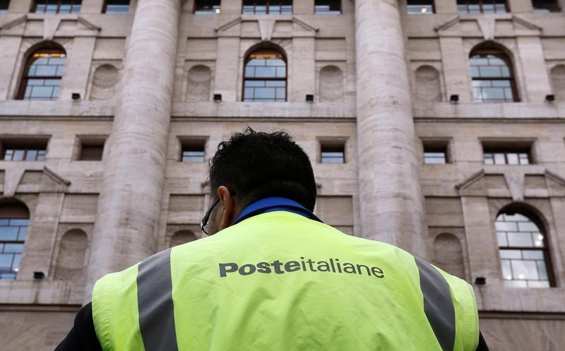 © Reuters. Un lavoratore delle Poste davanti alla sede della borsa, a Milano