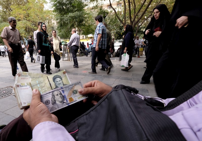 © Reuters. Money changer displays  U.S. and Iranian banknotes at the Grand Bazaar in central Tehran