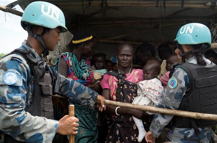 © Reuters. UN peacekeepers control South Sudanese women and children before the distribution of emergency food supplies at the United Nations protection of civilians site 3 hosting about 30,000 people displaced during the recent fighting in Juba, South Sudan