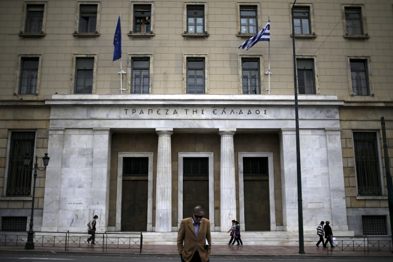 © Reuters. People make their way next to the headquarters of Bank of Greece in central Athens