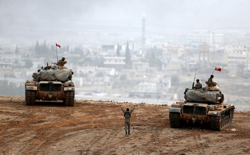 © Reuters. Turkish army tanks take position on top of a hill near Mursitpinar border crossing in the southeastern Turkish town of Suruc