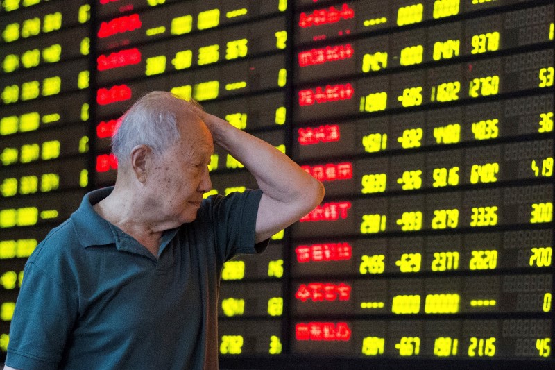 © Reuters. An investor looks at an electronic board showing stock information at a brokerage house in Nanjing