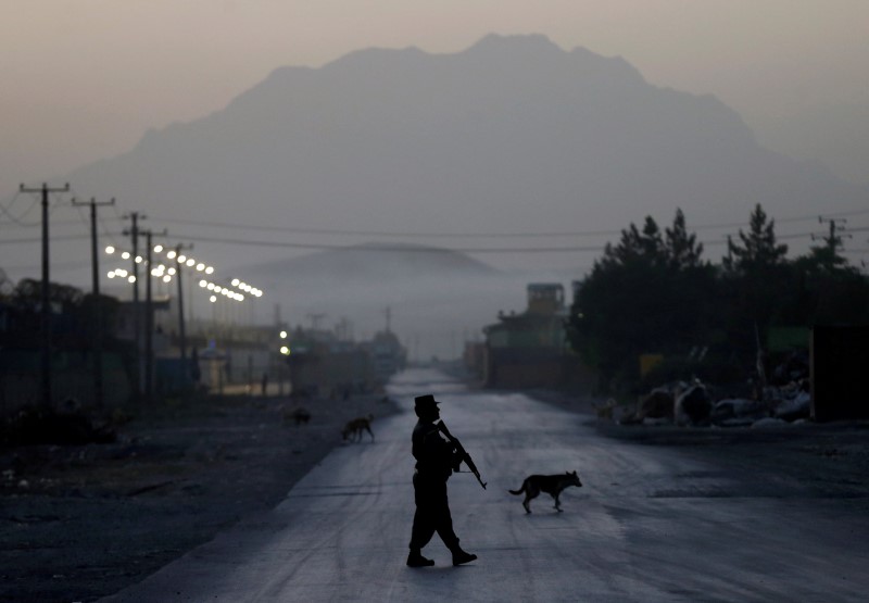 © Reuters. An Afghan policeman keeps guard near the site of a truck bomb attack in Kabul