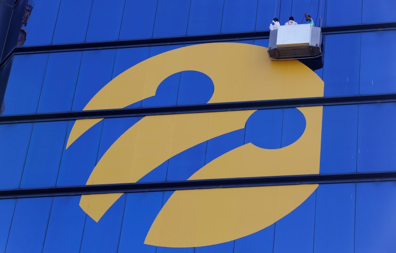© Reuters. Workers install the logo of Turkcell, country's top mobile operator, on the Tat Towers in Istanbul