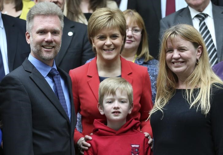 © Reuters. Gregg (L) Kathryn (R) and Lachlan Brain pose for photographers with Scotland's First Minister Nicola Sturgeon in Scotland's devolved Parliament in  Edinburgh, Scotland