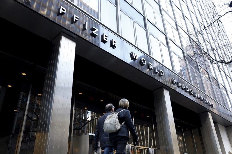 © Reuters. People pass the Pfizer World Headquarters building in New York