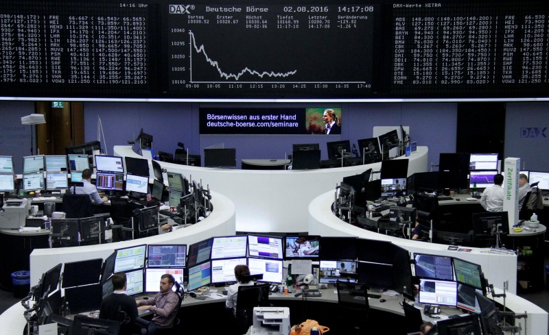 © Reuters. Traders work at their desks in front of the German share price index DAX board in Frankfurt