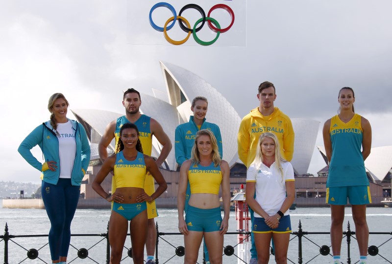 © Reuters. Australian Olympic team members pose in front of the Sydney Opera House during the official launch of the team uniforms for the 2016 Rio Olympics