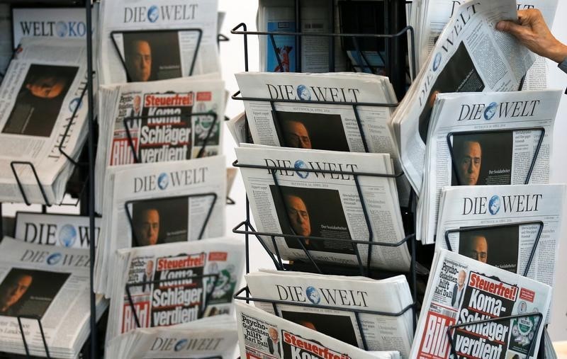 © Reuters. A shareholder takes a newspaper during  the annual shareholders meeting of German newspaper publisher Axel Springer in Berlin