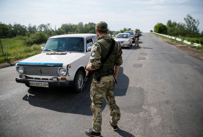 © Reuters. Ukrainian servicemen check cars at checkpoint near Slaviansk