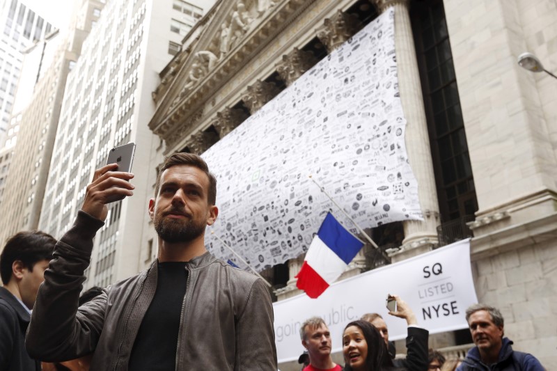 © Reuters. Jack Dorsey, CEO of Square and CEO of Twitter, uses his phone to live cast during an event outside of the New York Stock Exchange to celebrate the IPO of Square Inc., in New York