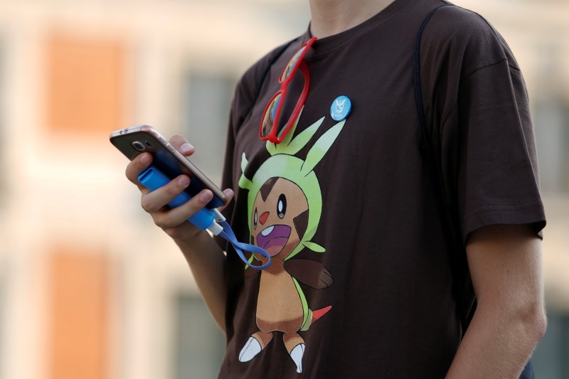 © Reuters. A young man plays the augmented reality mobile game "Pokemon Go" by Nintendo at Puerta del Sol square in Madrid