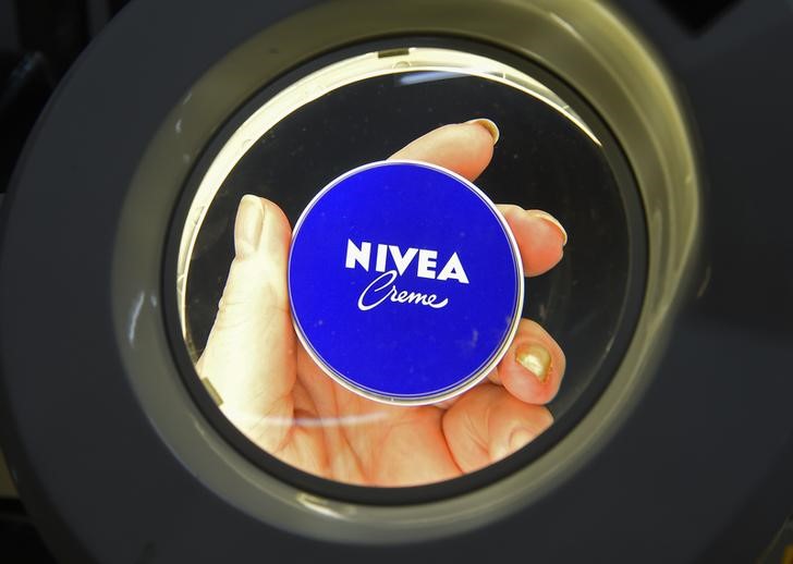 © Reuters. An employee examines the covers of a Nivea skin cream cover during a quality control inspection at production line of German company Beiersdorf AG in Hamburg