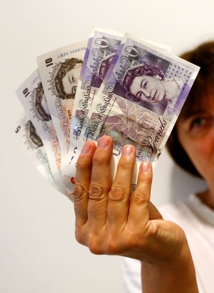 © Reuters. An employee holds British pound banknotes in a bank at the main train station in Munich