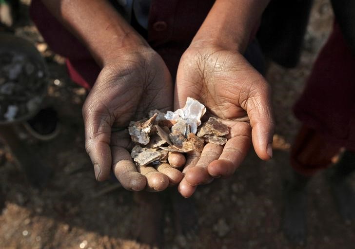 © Reuters. A girl show some of the mica flakes she has collected whilst working in a open cast illegal mine in Giridih district